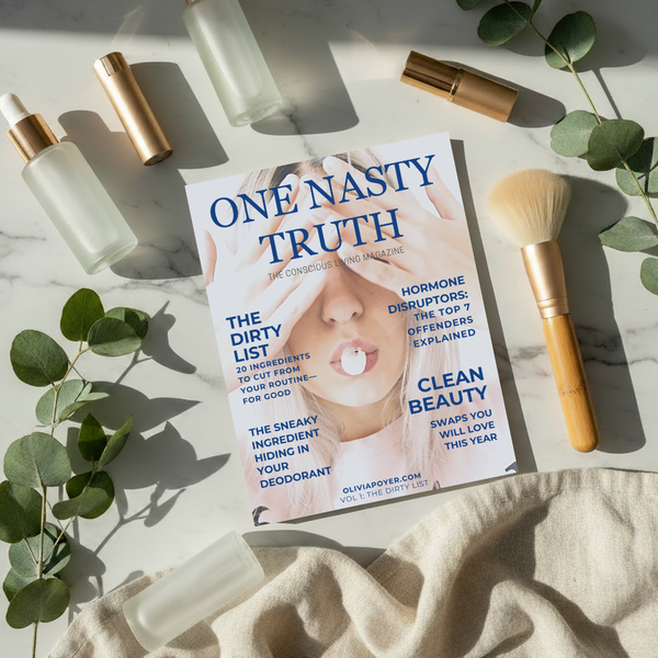Flat lay of One Nasty Truth magazine, a guide to Low-Tox Living, on a marble counter top with product bottles splayed out. 