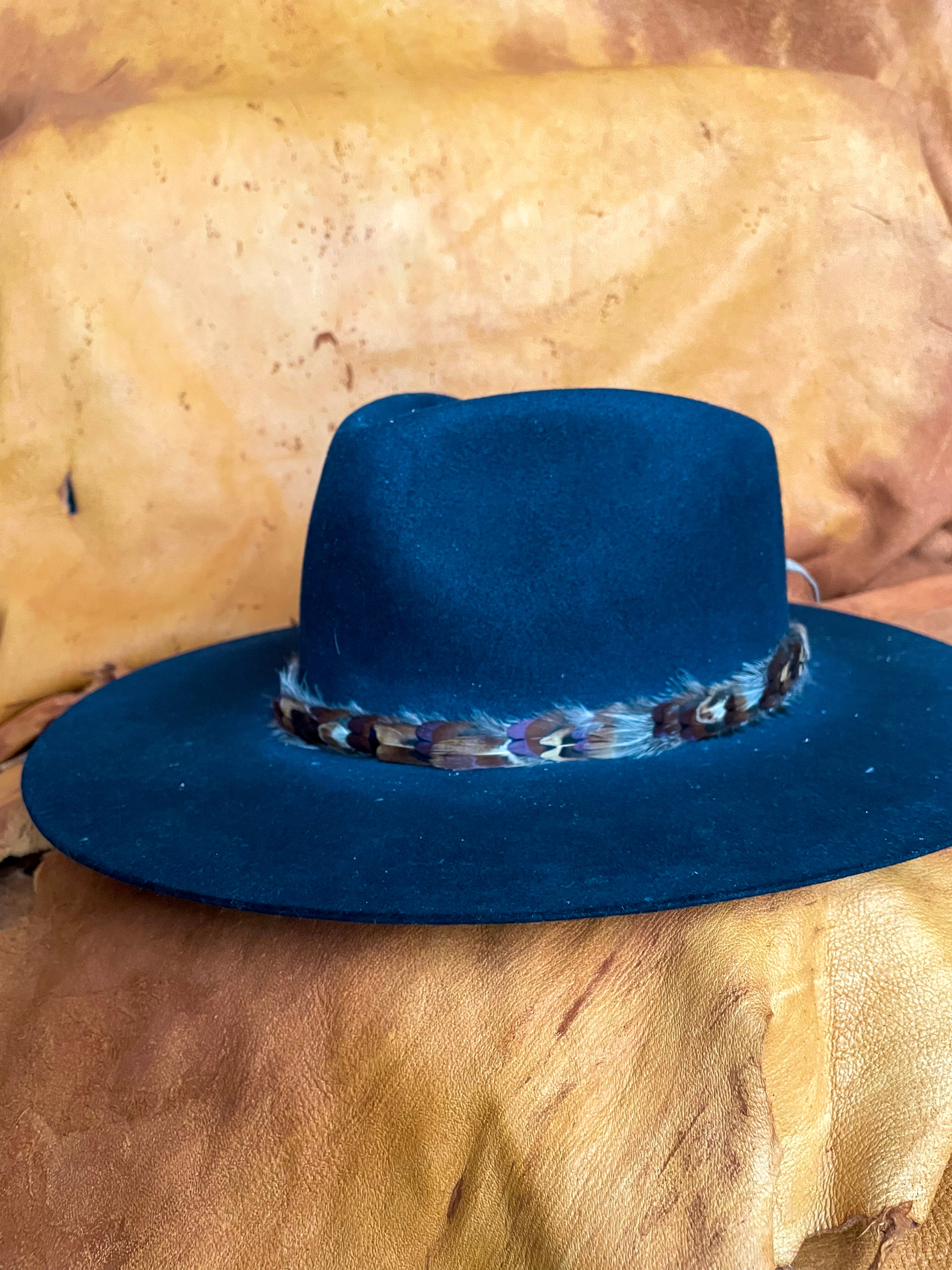 A front angle view of a handmade feather hatband with rust, blue, and golden pheasant feathers on a black felt hat.