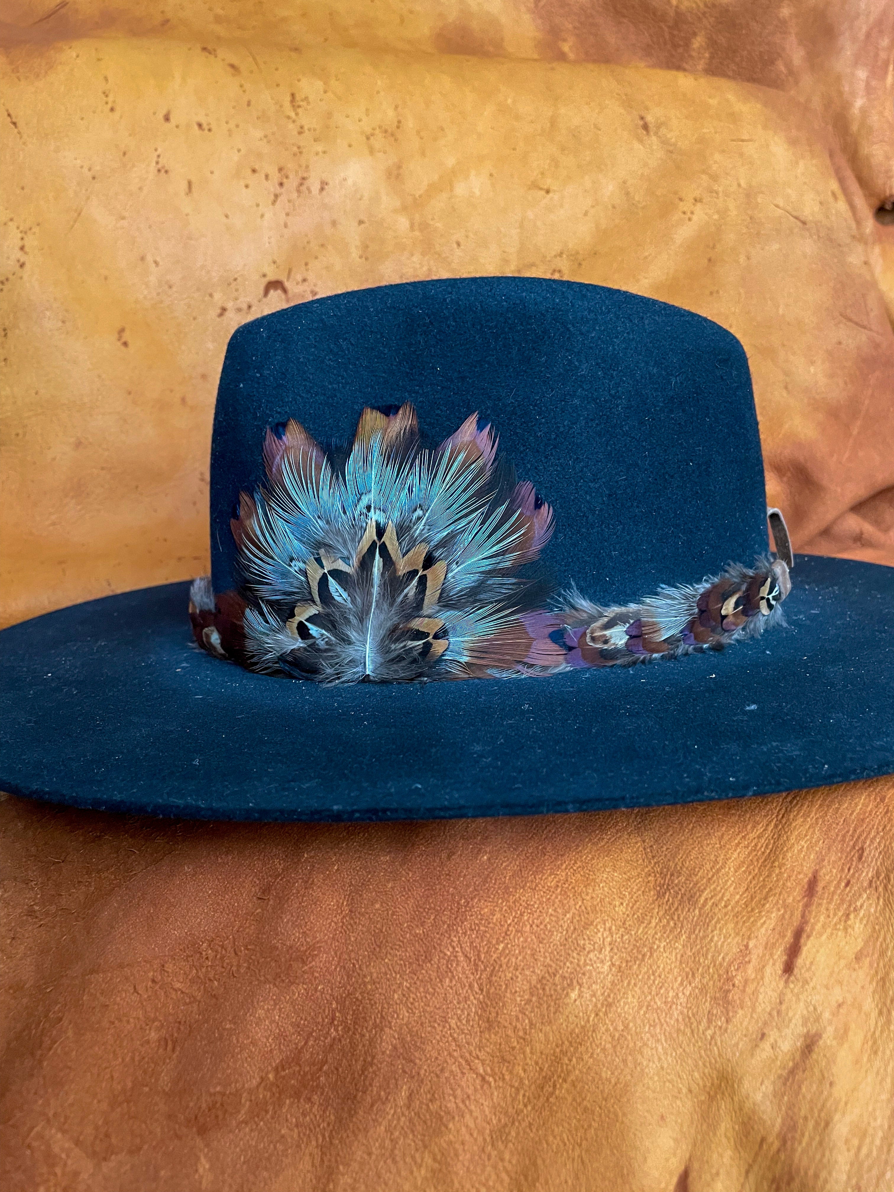 The side view of a black felt hat with a one of a kind hatband and matching medallion. 
