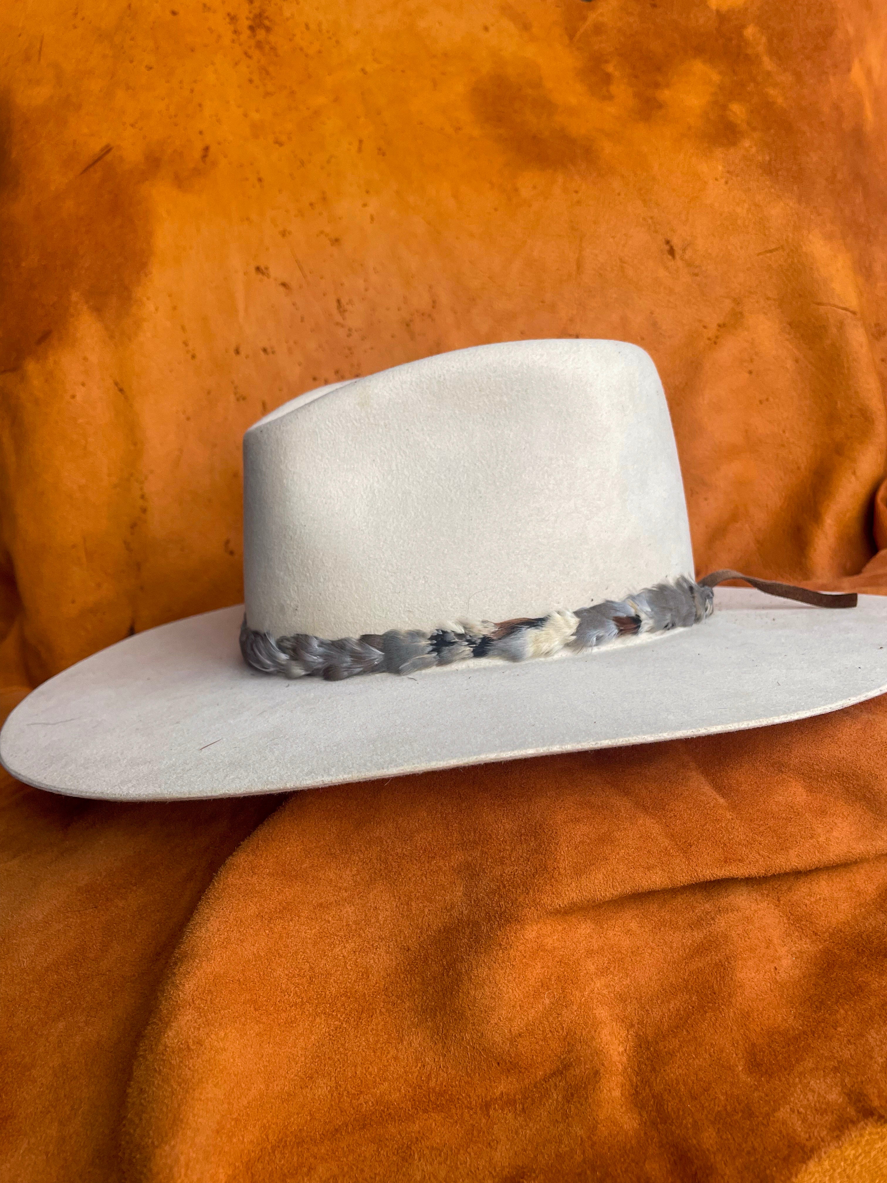 Earthy feather hatband inspired by muted landscapes and made of chukar feathers. 