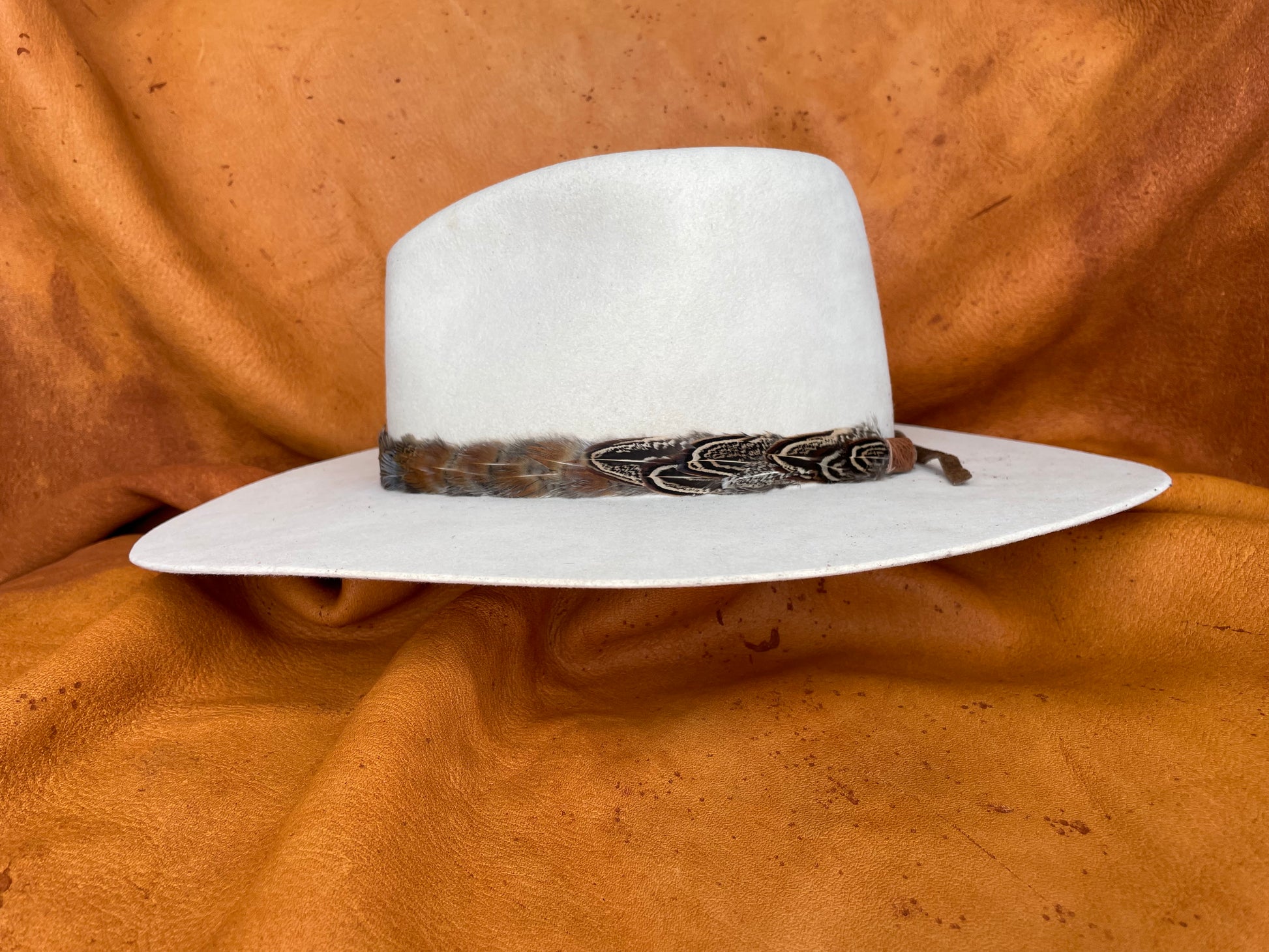Green, gold, and maroon feather hatband side view