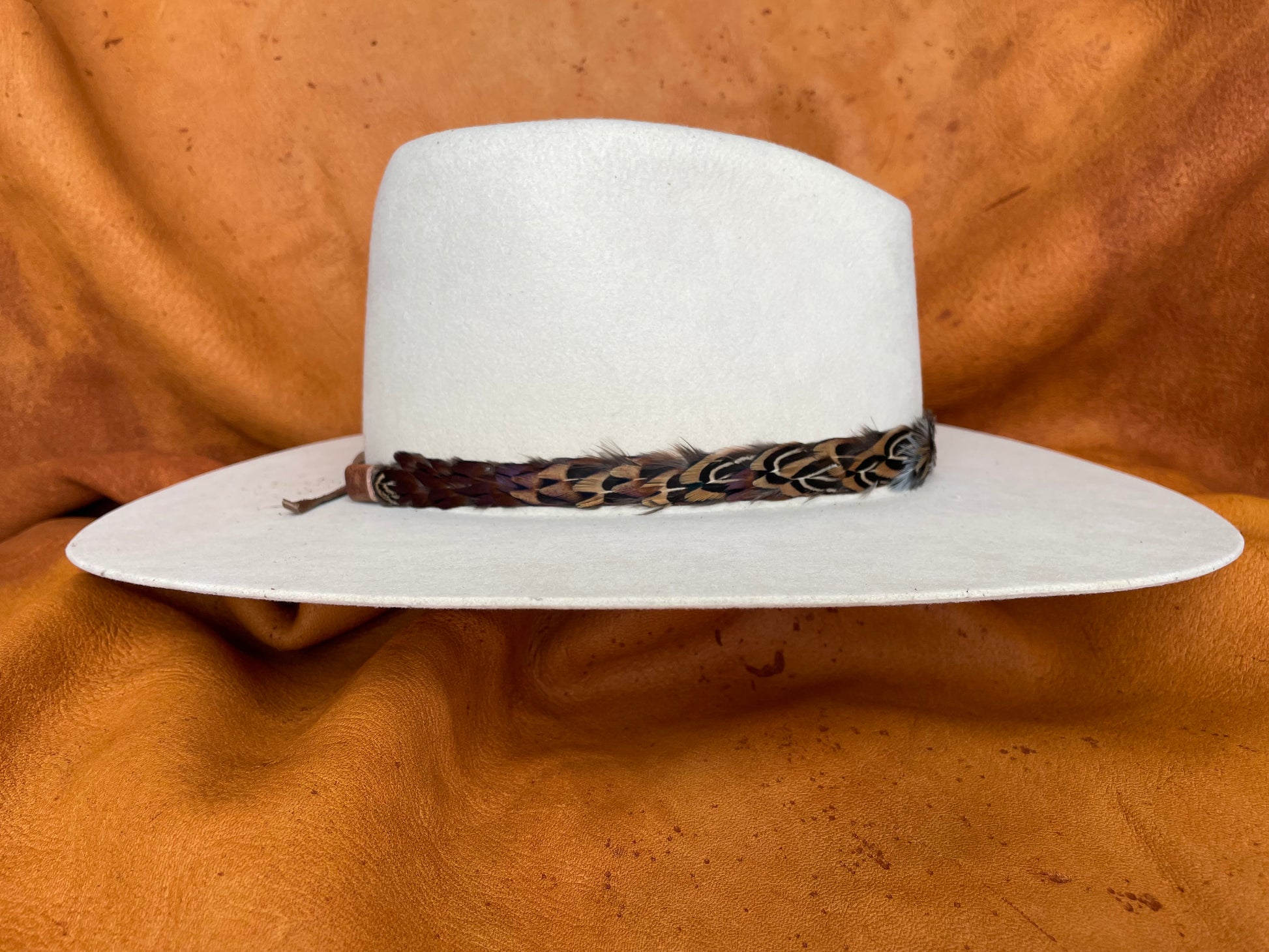Green, gold, and maroon feather hatband side view