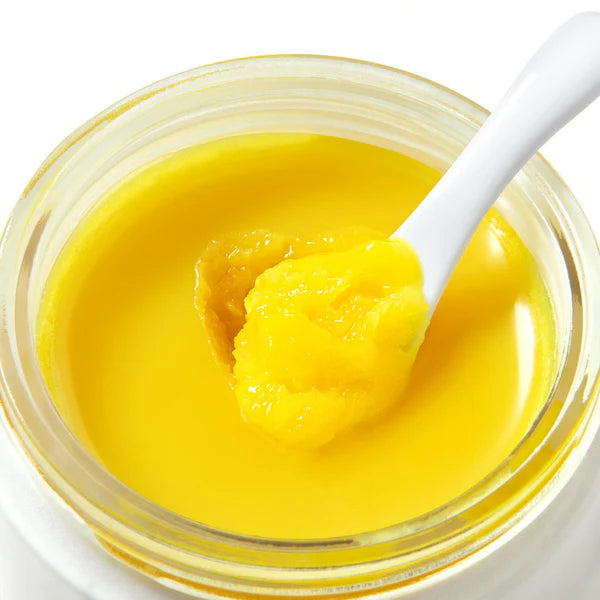 Crunchi Cleansing Balm jar with a small spatula scooping out balm, displayed on a clean neutral background.