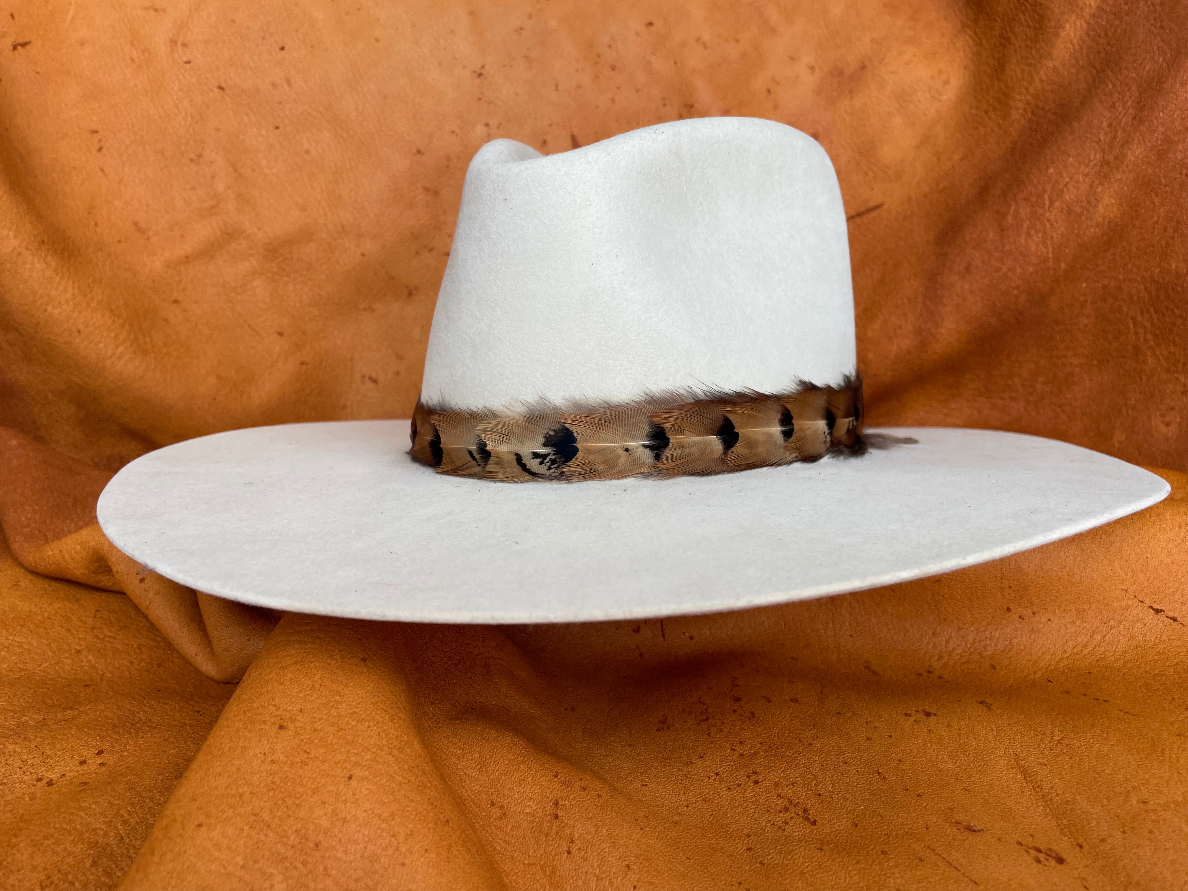 Close-up of gradient feather pattern hatband on cream hat, front angle