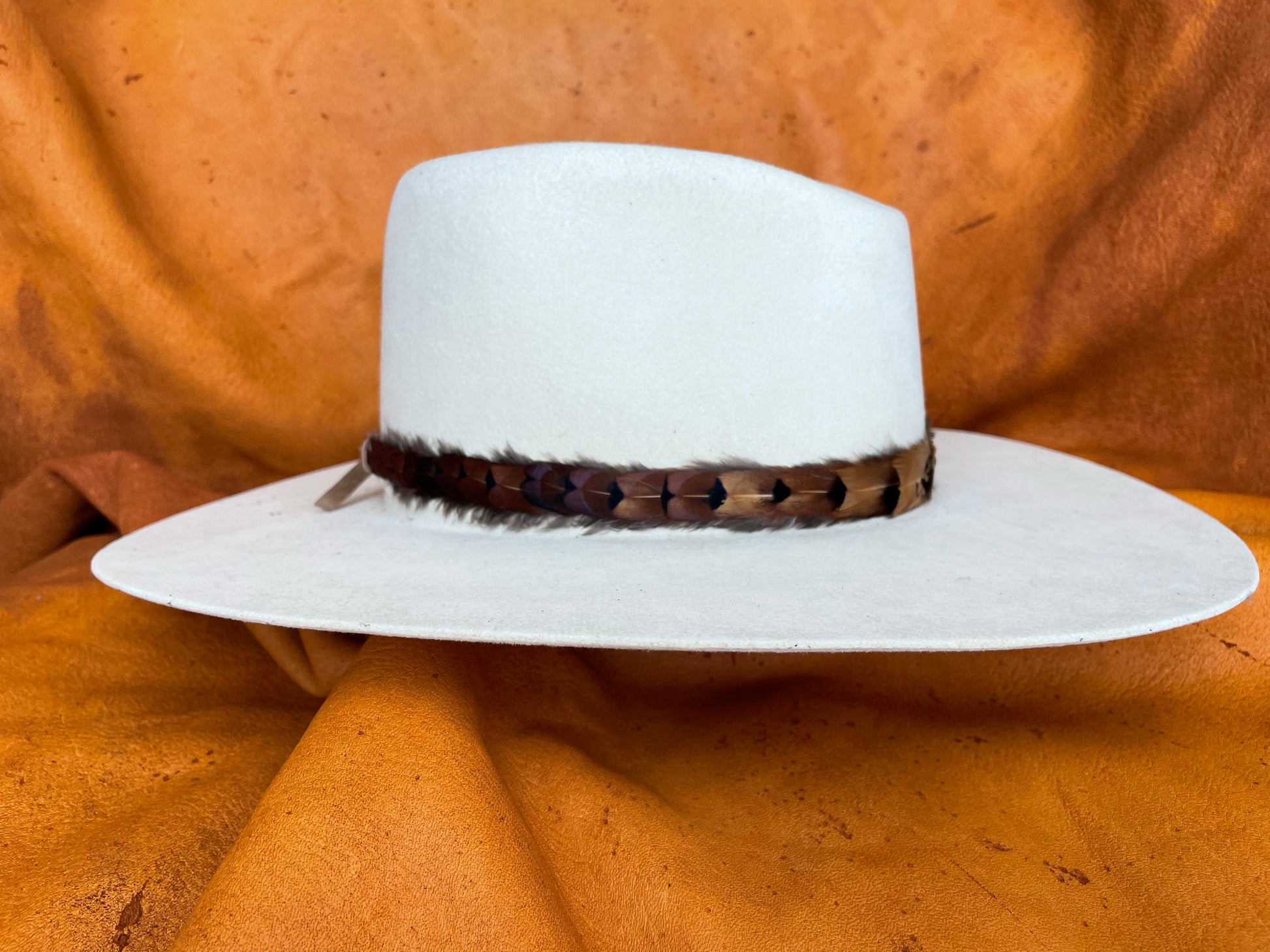 Golden rooster pheasant feather hatband on cream hat