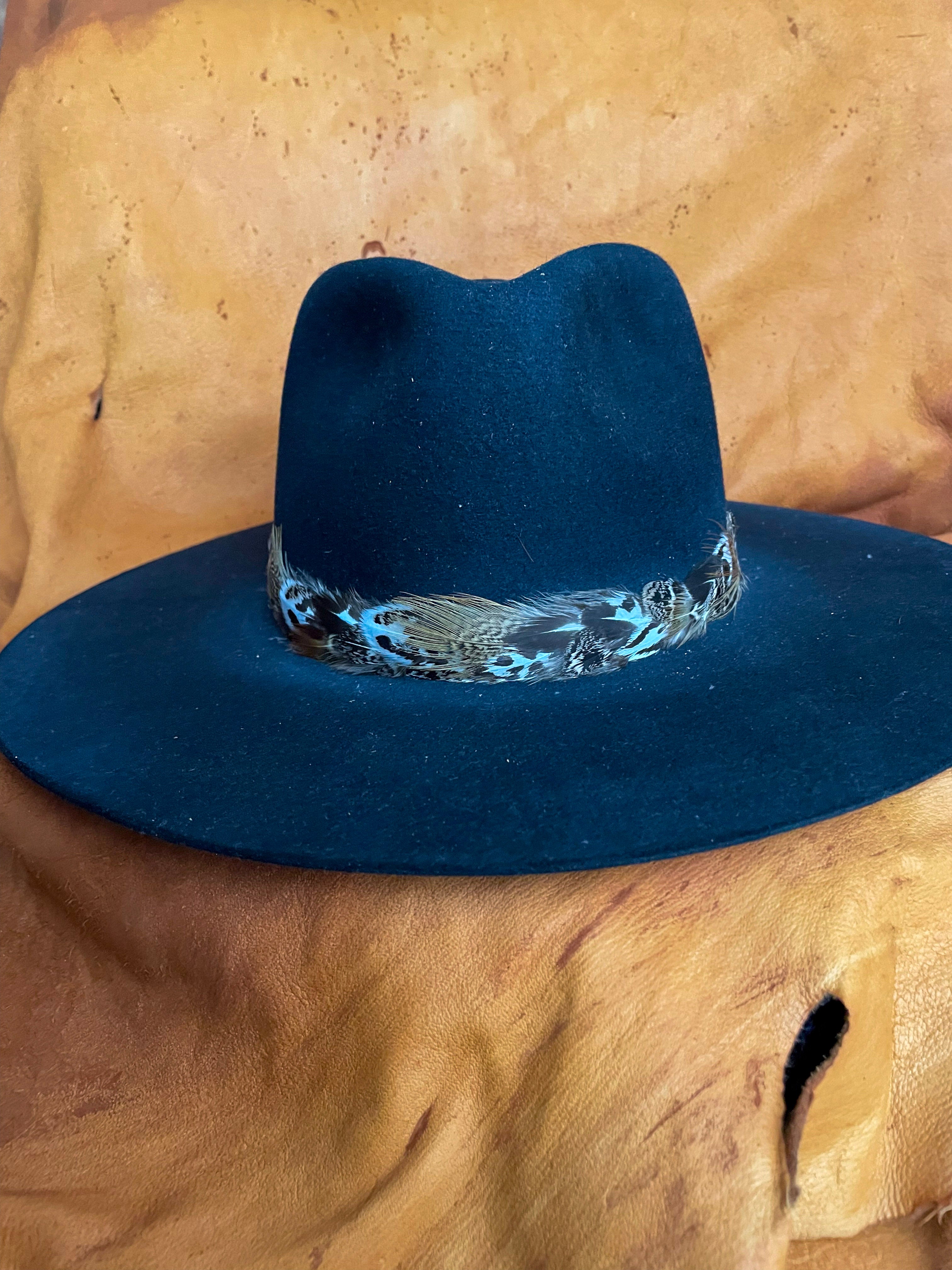 A front view of a Sage Grouse and Pheasant feather hatband styled on a black felt hat.
