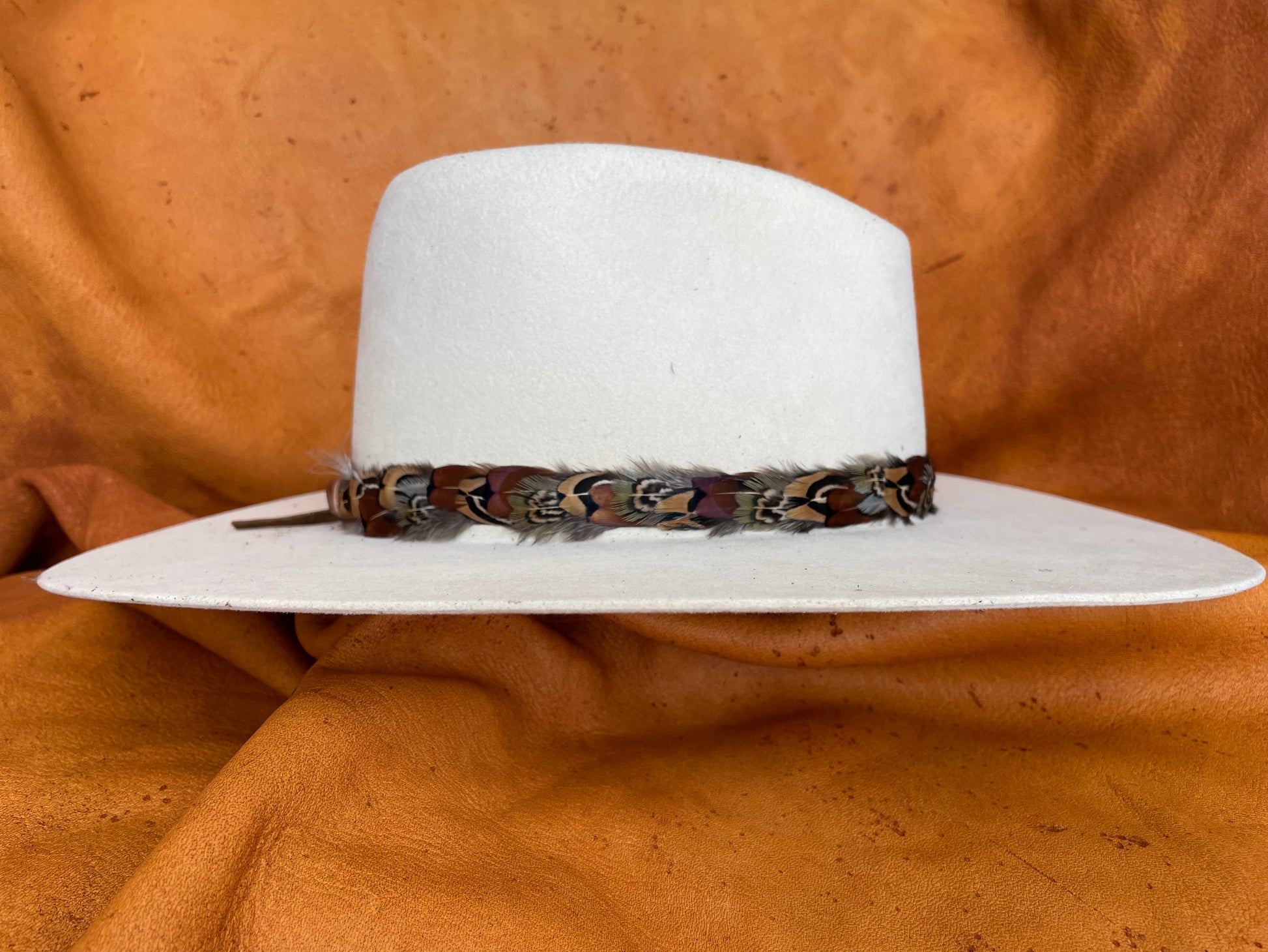 Hatband with emerald, maroon, and gold feathers