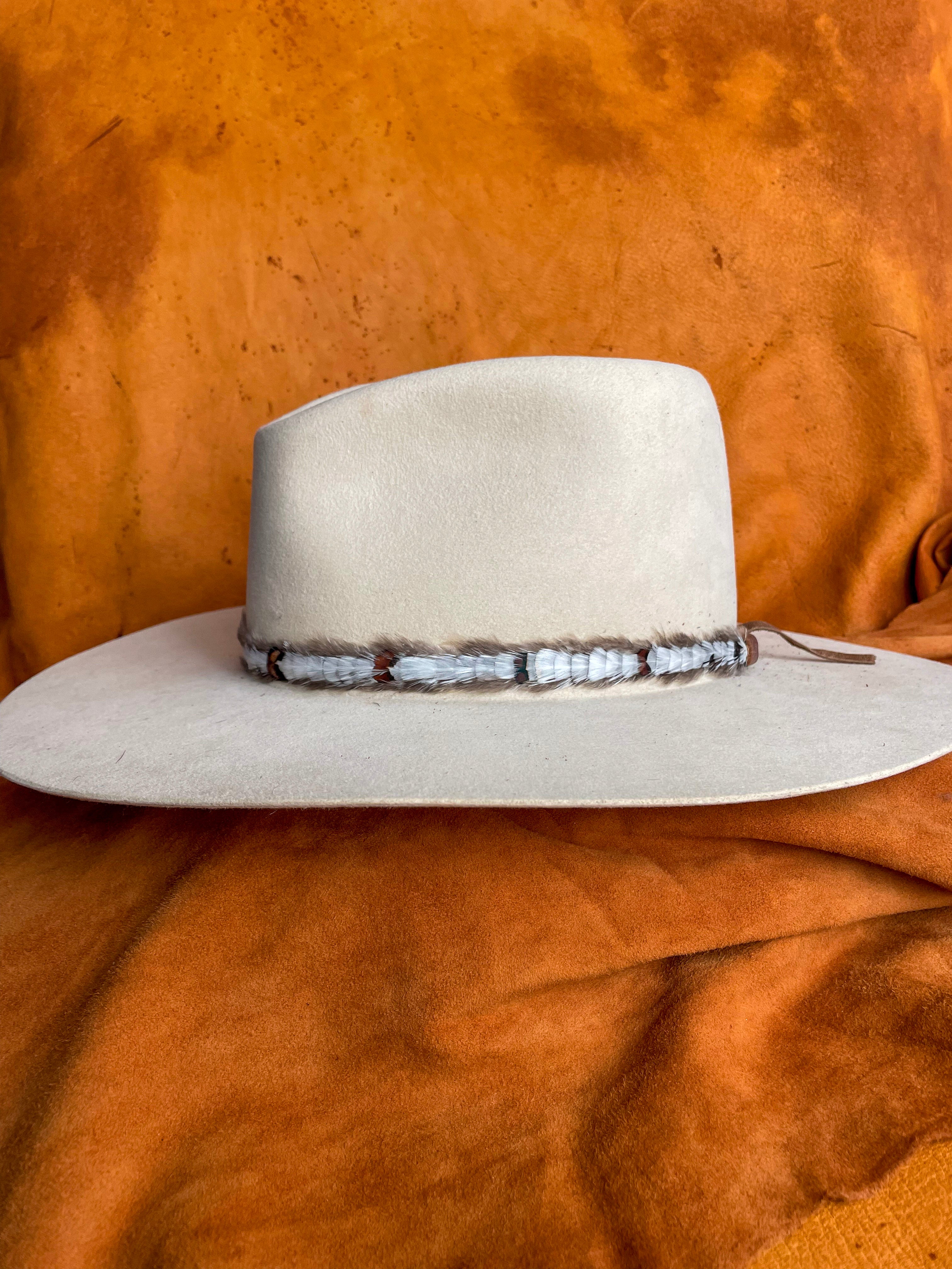 Clean and simple feather hatband design on an ivory felt hat.