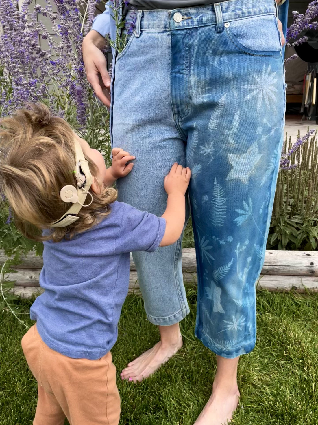 Short video of Olivia’s son Bode pointing to wildflowers tucked into the pocket of cyanotype jeans worn by her friend Jen — showcasing handmade, nature-inspired textile design.