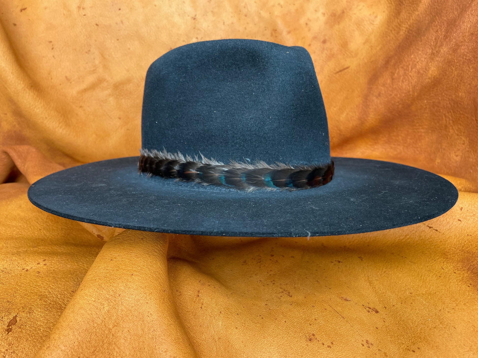 Artisan feather hatband on black hat