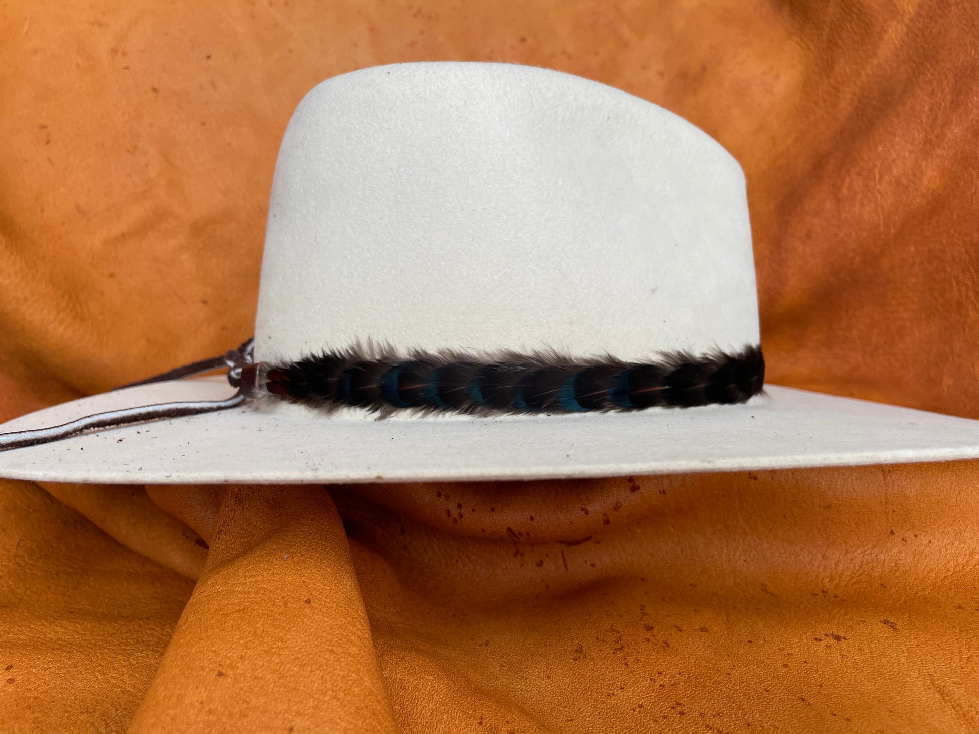 Subtle maroon & black feather hatband, side view on cream hat
