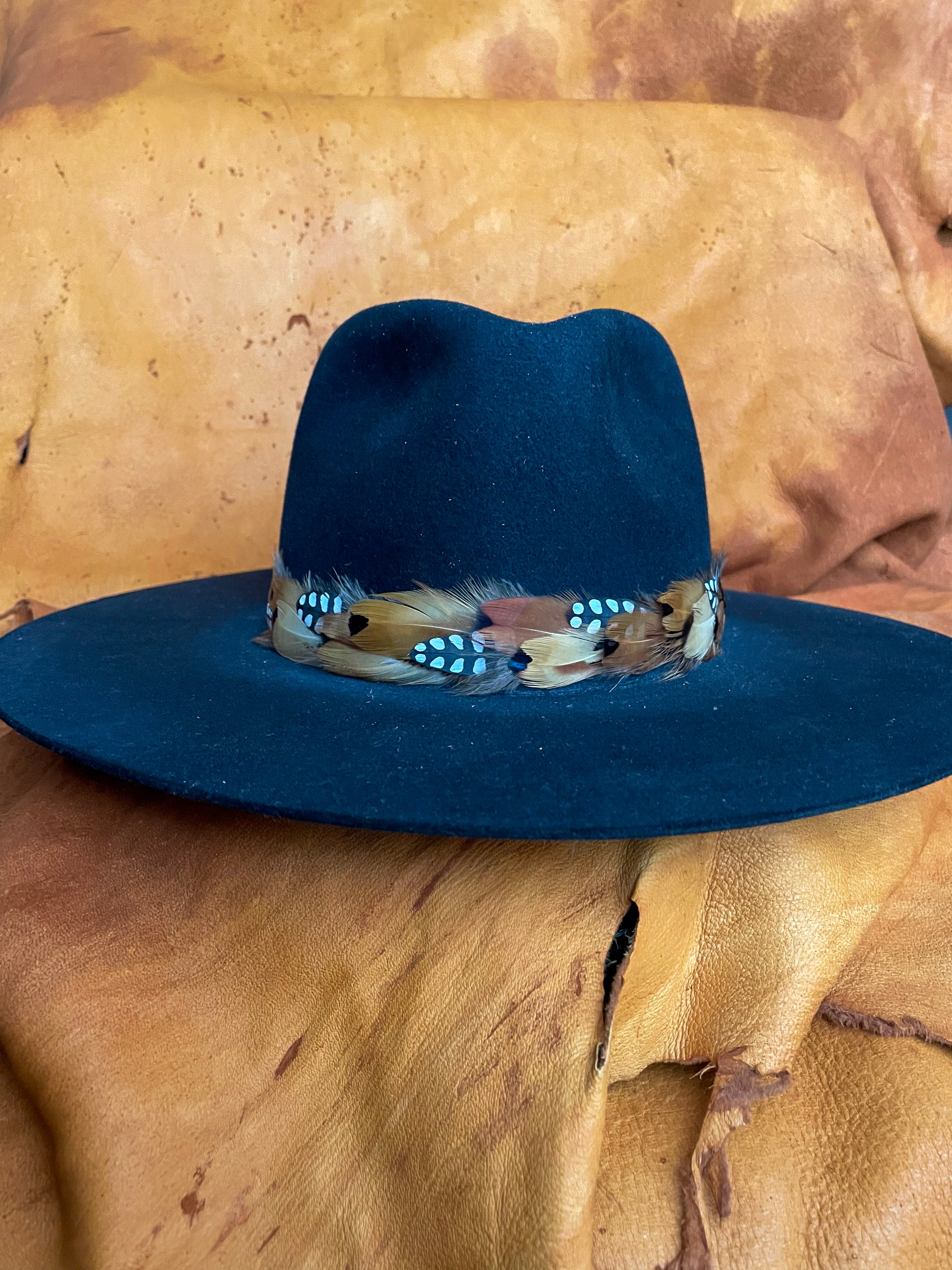 Handmade feather hatband with golden pheasant and quail feathers with black polka dot accents on a black felt hat.