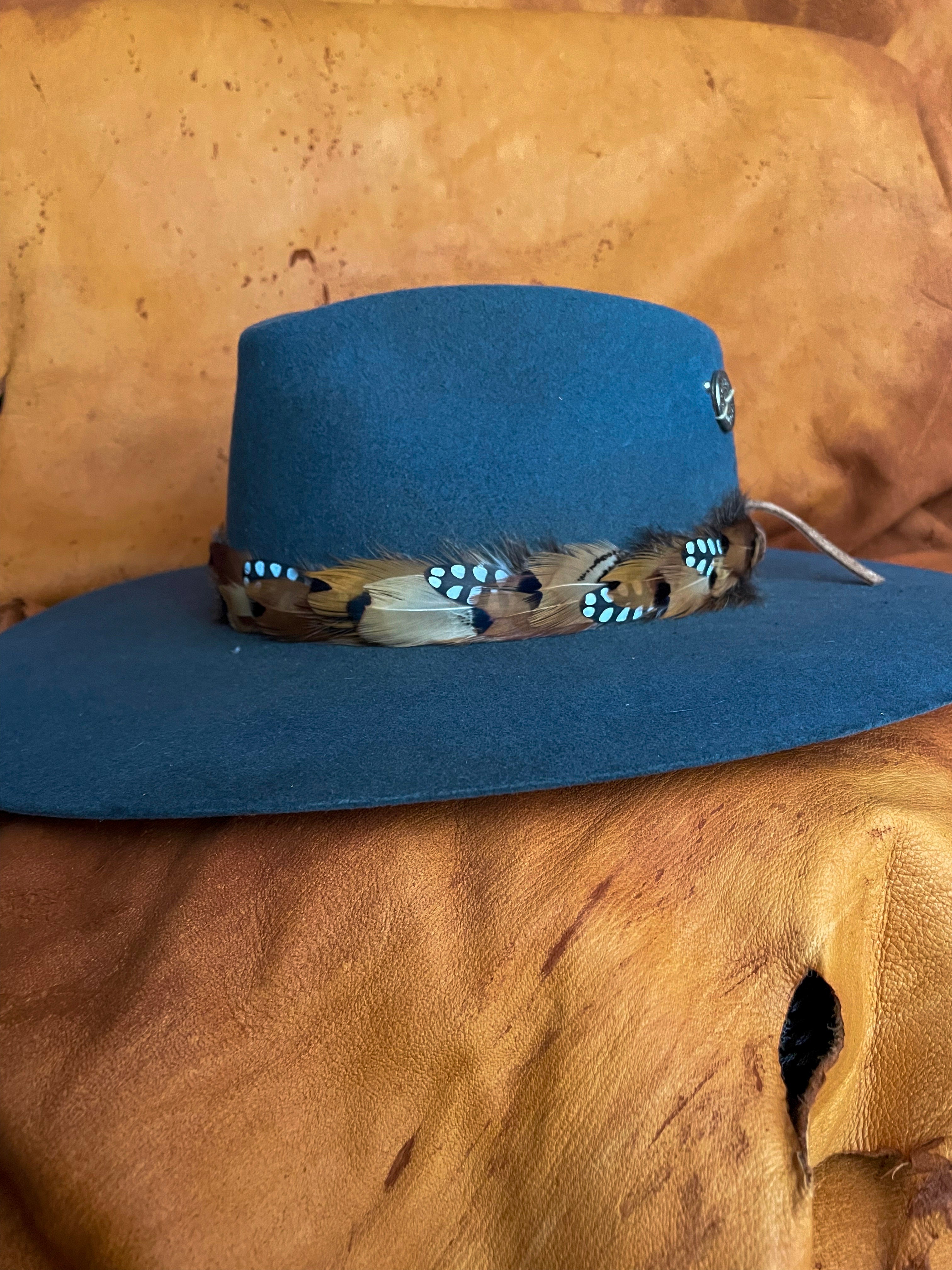One-of-a-kind feather band with light and playful color pattern on a steel blue felt hat.