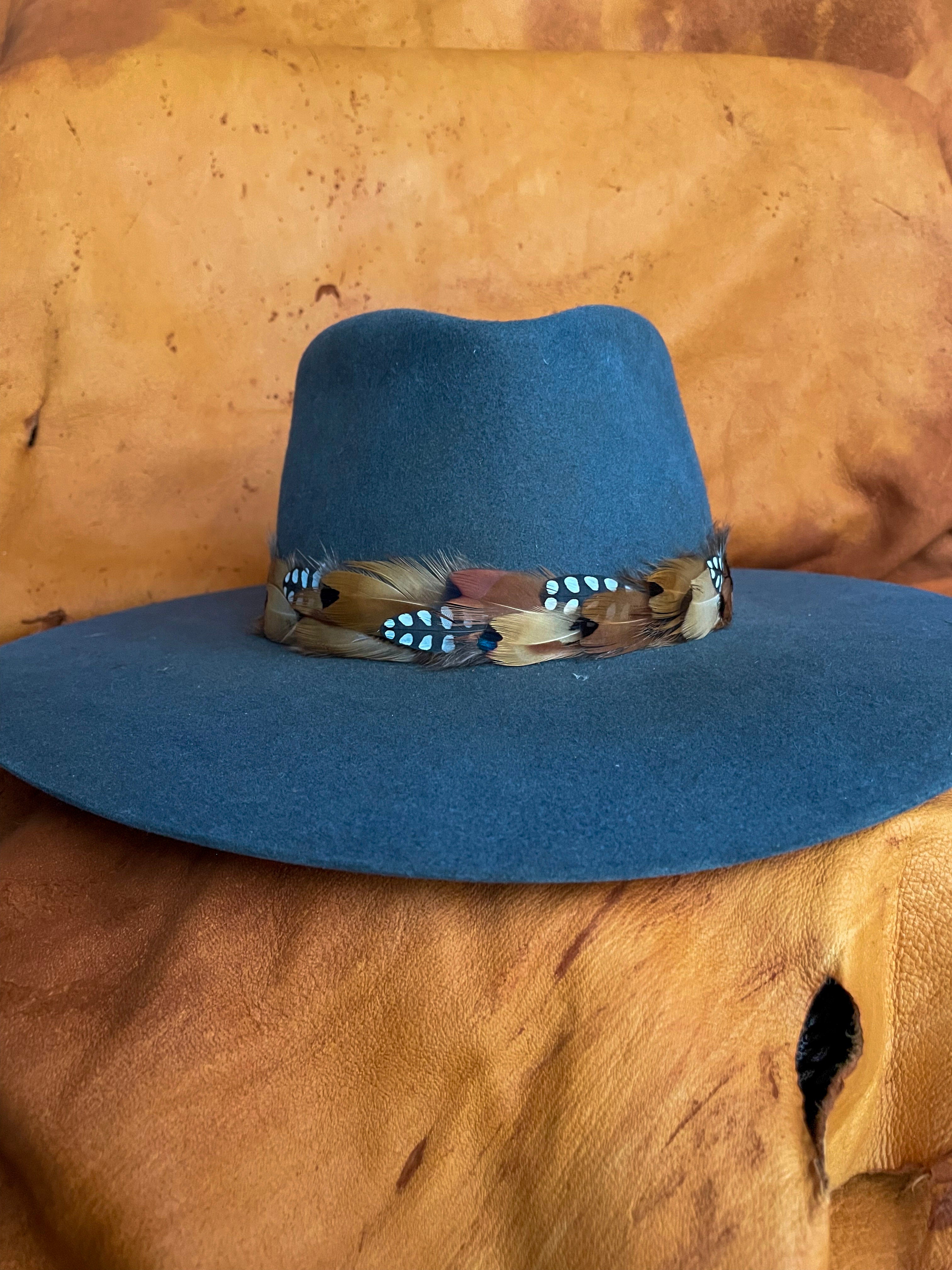 Handmade feather hatband with golden pheasant and quail feathers with black polka dot accents on a steel blue felt hat. 