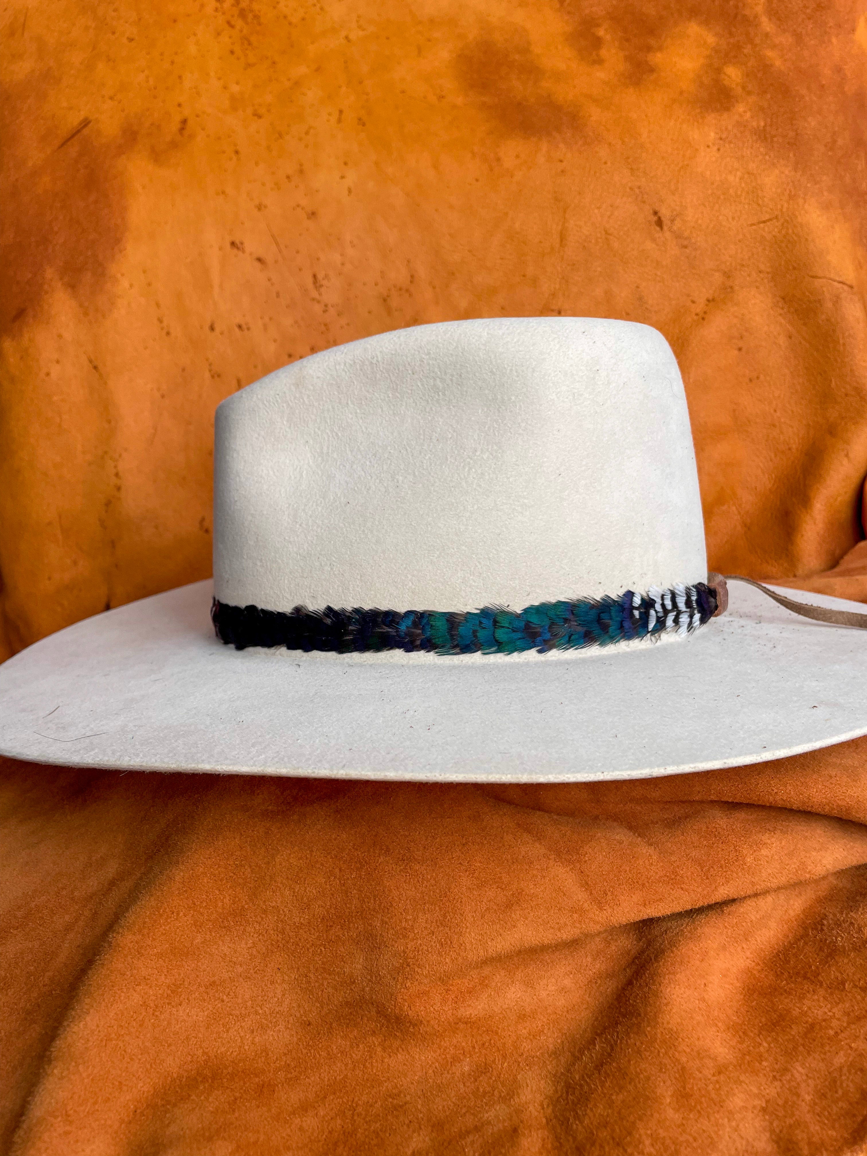 Color-block feather band, showcasing the emerald green block on a cream felt hat. 