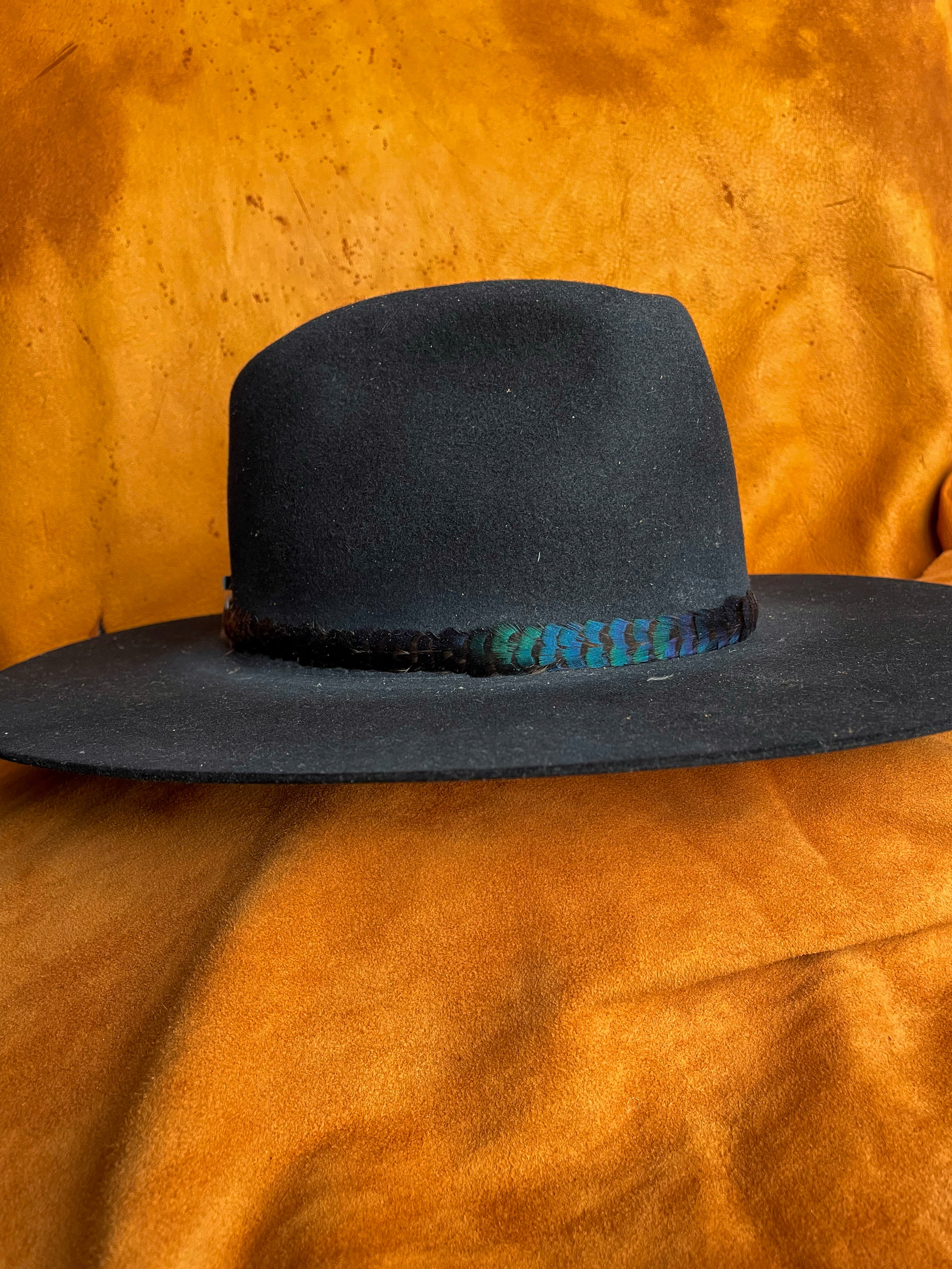 Iridescent feather band with natural color shift on a black felt hat. 