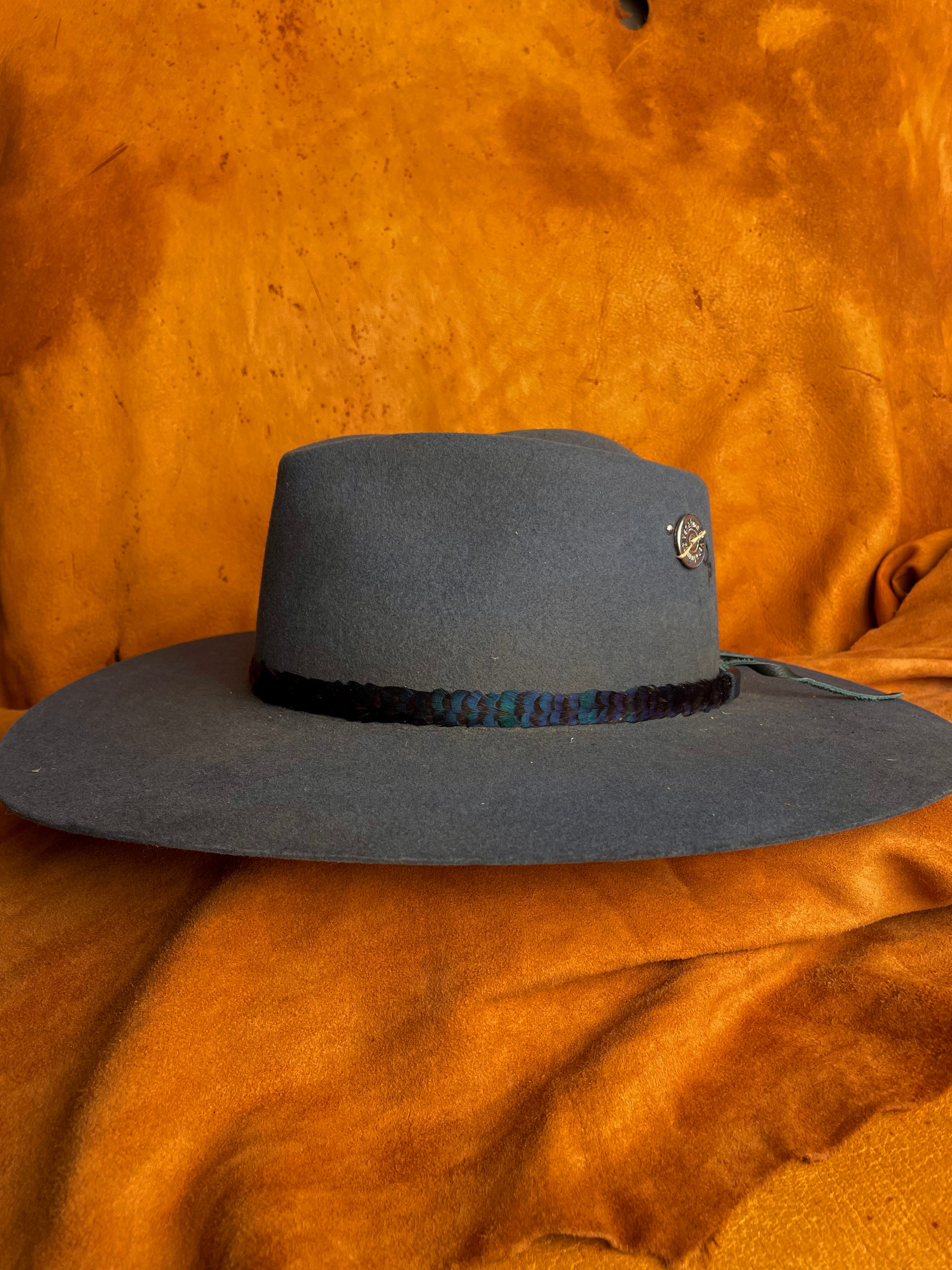 One-of-a-kind green feather hatband worn on a steel blue hat. 