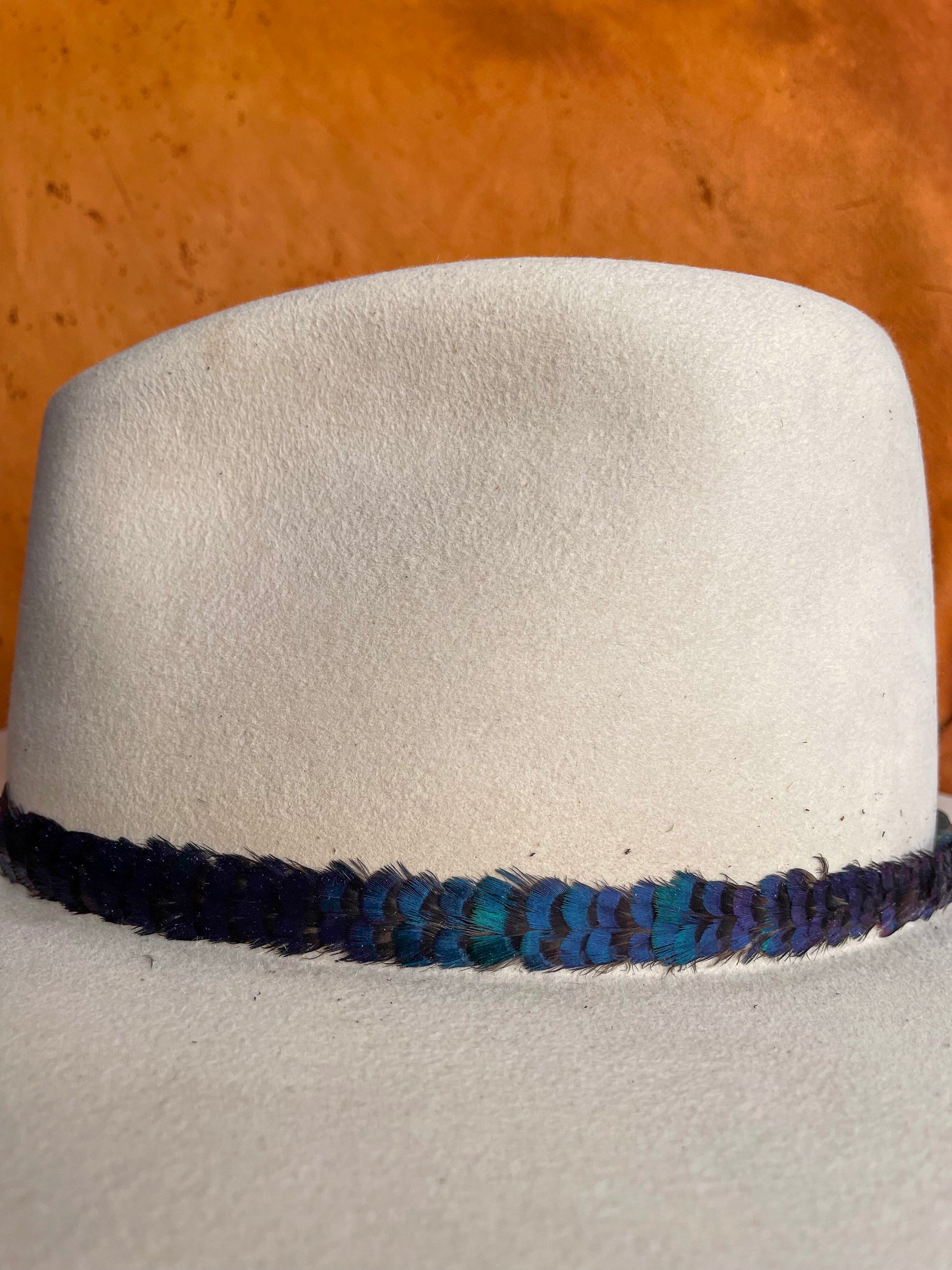 Close-up of shimmering green feather detail on the Verdant hat band. 