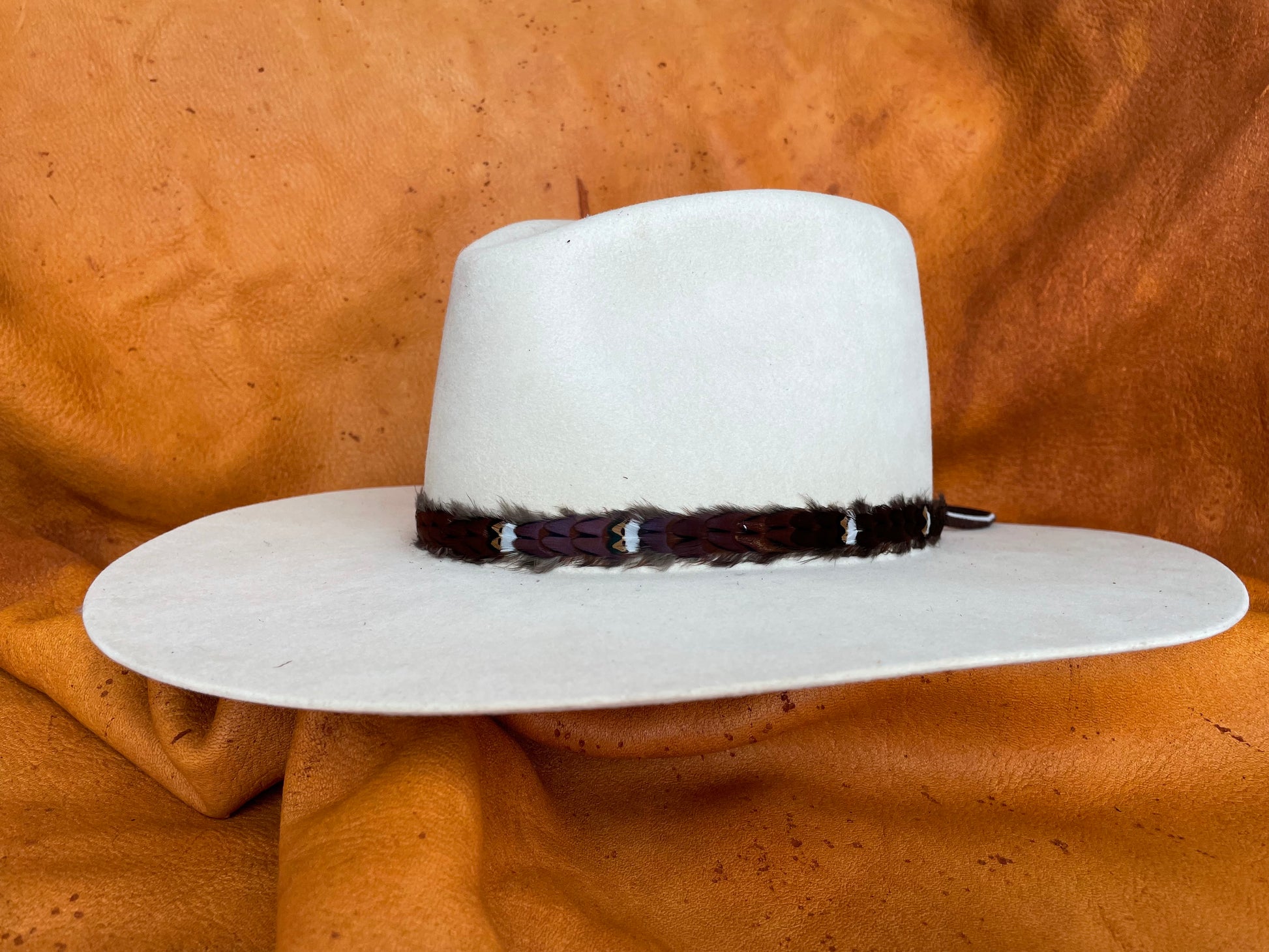 Maroon feather hatband with golden accents, angled