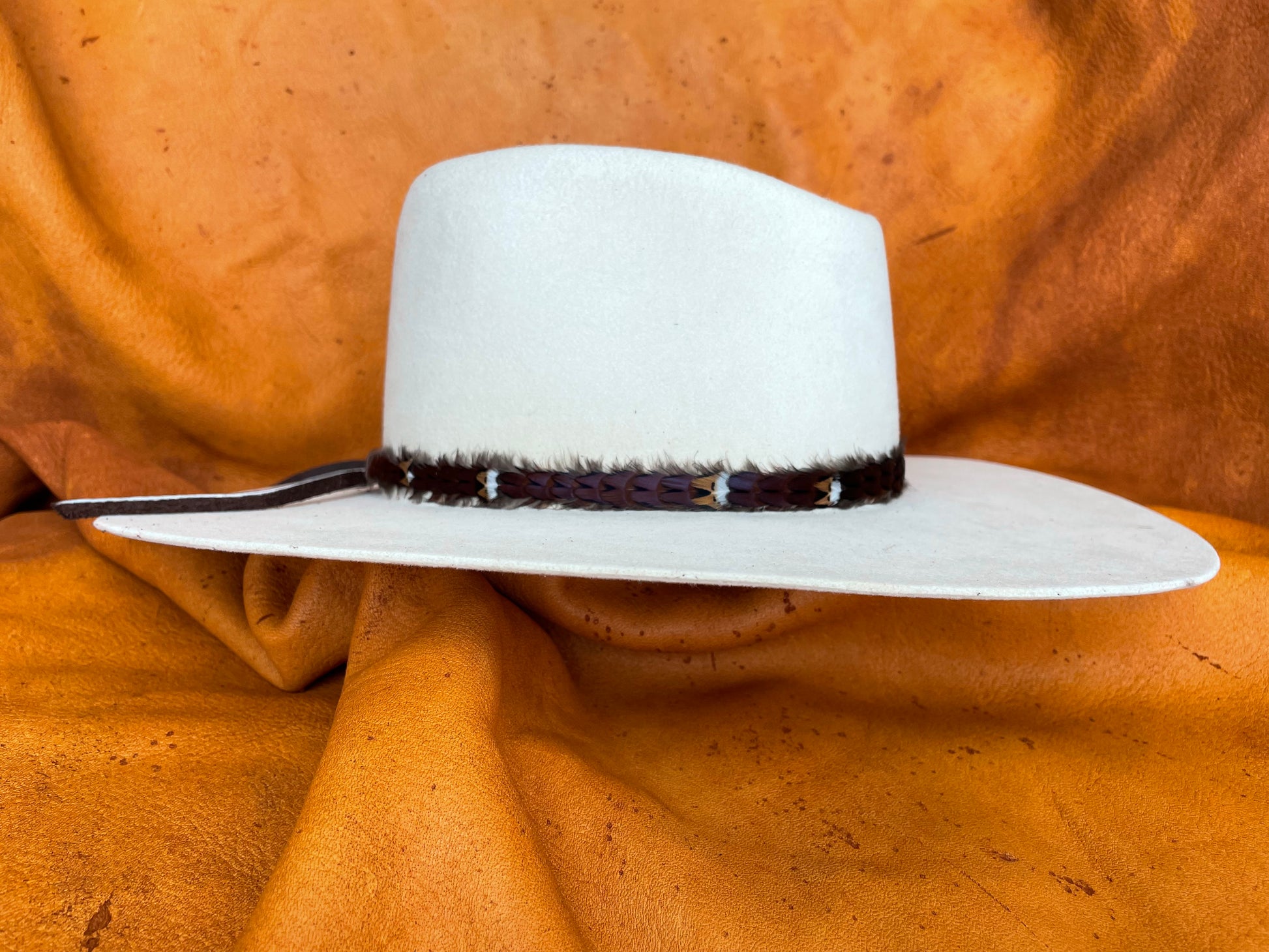Maroon feather hatband with golden accents, side view